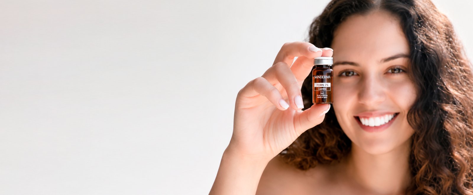Profissional Skinderma segurando ampola de PDRN 2% para tratamento facial regenerativo